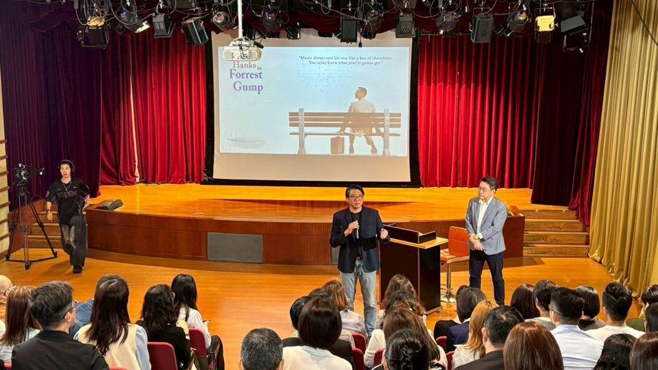 憲哥在台上演講，台下坐滿觀眾